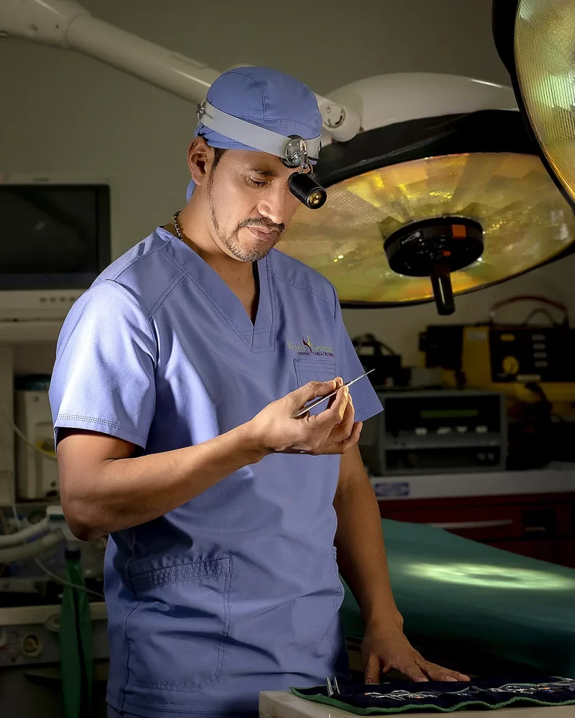 Dr. Víctor González, cirujano plástico en Cuenca especializado en rinoplastia y contorno corporal, de pie en un quirófano moderno.